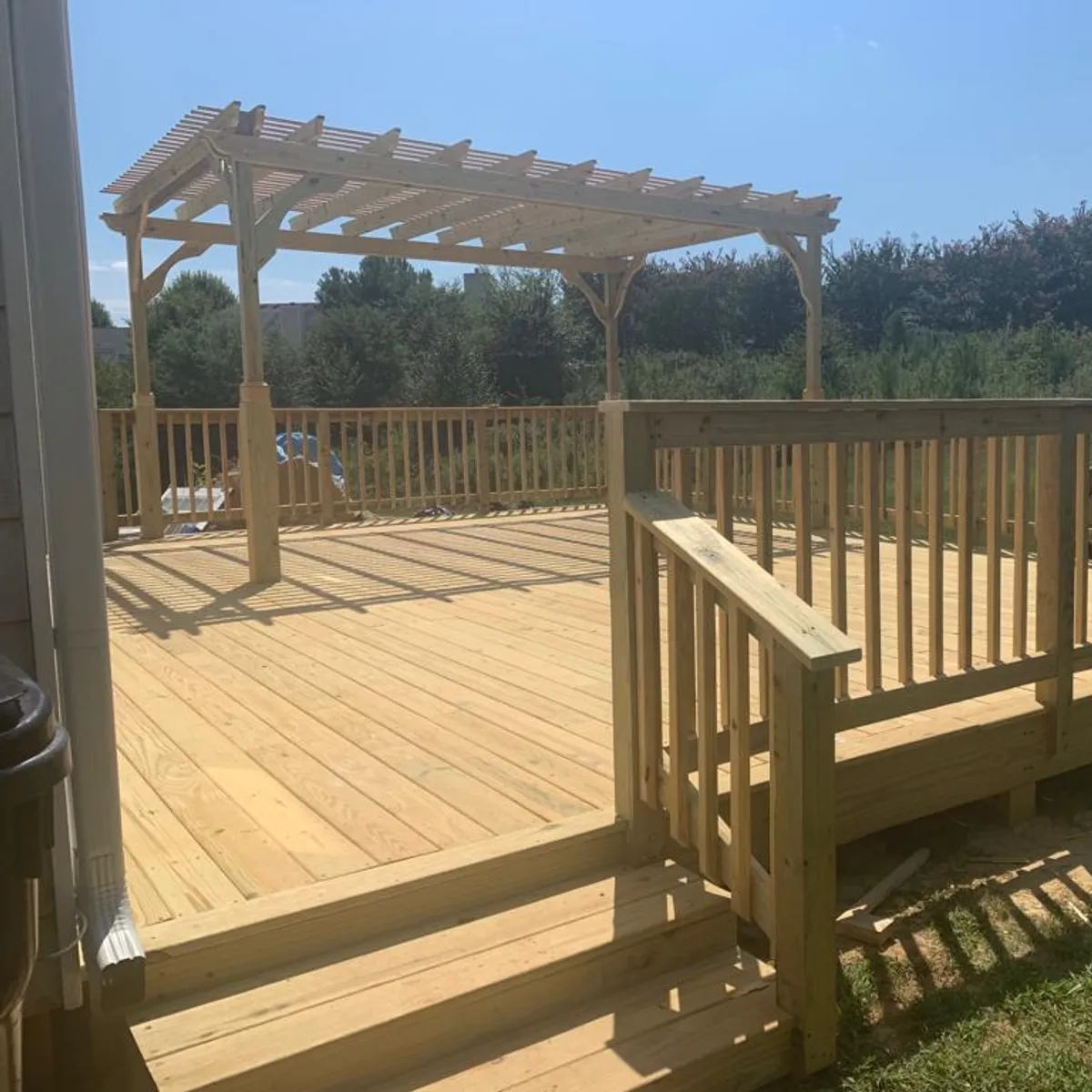 A pressure-treated deck with a pergola over one end