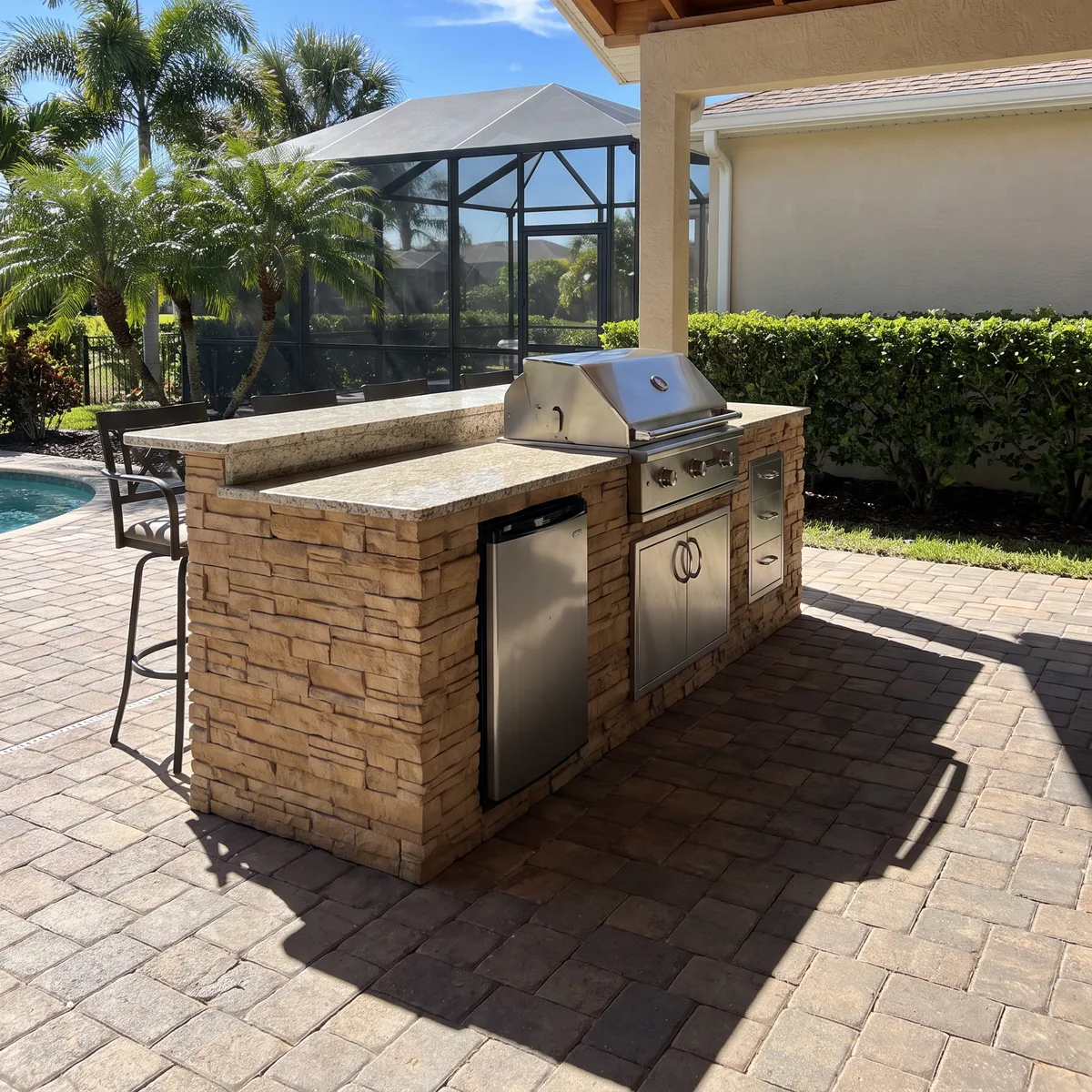 A built-in outdoor kitchen island with a stone base and a stainless grill